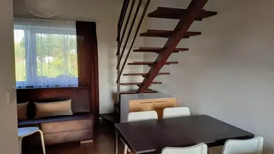 a dining room with a table and a spiral staircase at Apartmány Vinařství Klučov in Lstiboř