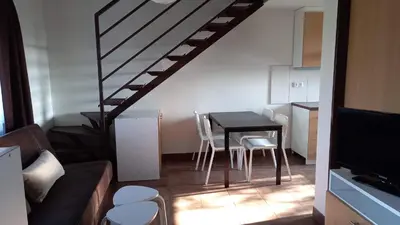a small kitchen with a table and a staircase at Apartmány Vinařství Klučov in Lstiboř
