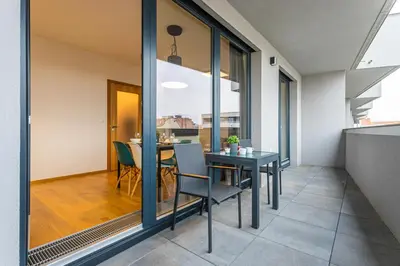 a dining room with a table and glass walls at Apartment Oscar with garage in Prague