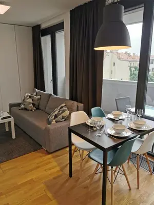 a living room with a table and chairs and a couch at Apartment Oscar with garage in Prague