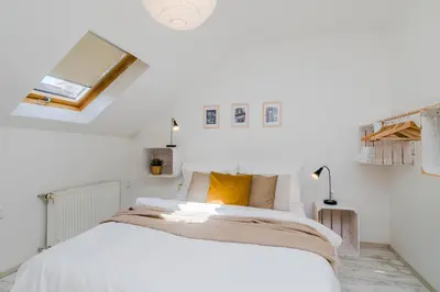 a white bedroom with a large bed with yellow pillows at APTs in OLD TOWN PRAGUE by Michal&Friends in Prague