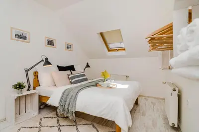 a white bedroom with a bed and a couch at APTs in OLD TOWN PRAGUE by Michal&Friends in Prague