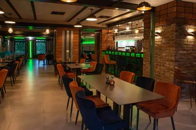a restaurant with tables and chairs and a bar at Hotel JURKOS in Příbram