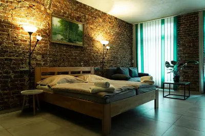 a bedroom with a bed and a brick wall at Hotel JURKOS in Příbram