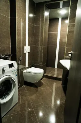 a bathroom with a toilet and a washing machine at Hotel JURKOS in Příbram