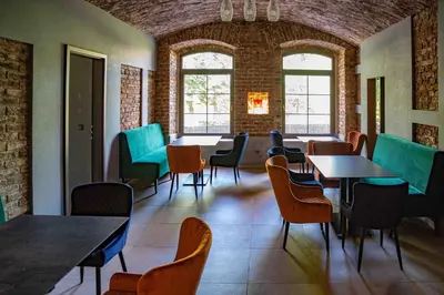 a dining room with tables and chairs and windows at Hotel JURKOS in Příbram