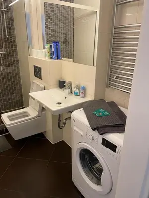 a bathroom with a washing machine and a sink at Apartmen -Studio in Prague