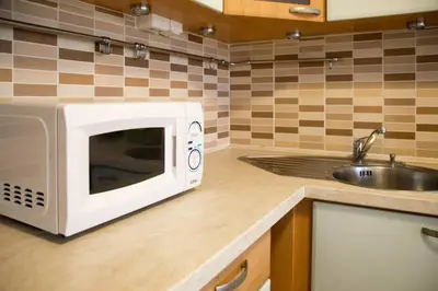 a kitchen with a microwave and a sink at Modern apartments - Airport 8mins in Prague