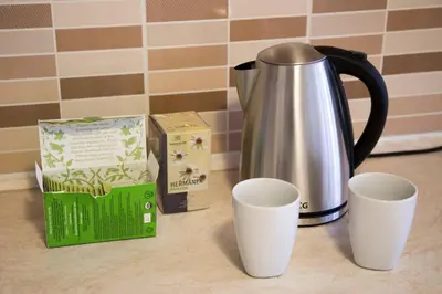 a coffee pot and two cups on a counter at Modern apartments - Airport 8mins in Prague