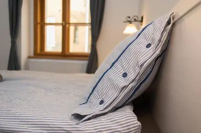 a bed with a pillow on it with a window at Apartment Florenc with 3-bathrooms & bedrooms in Prague