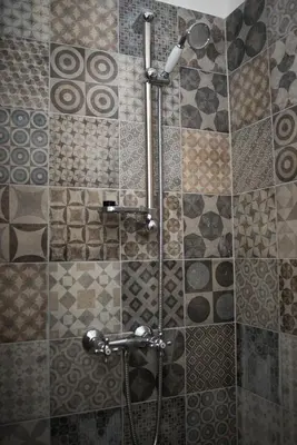 a shower in a bathroom with a tile wall at Apartment Florenc with 3-bathrooms & bedrooms in Prague