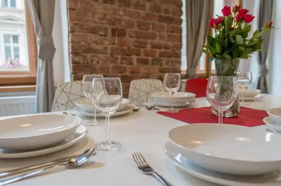 a table with plates and glasses and a vase of flowers at Apartment Florenc with 3-bathrooms & bedrooms in Prague