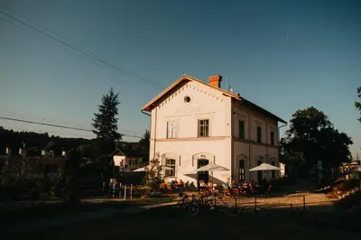 a large white building with tables in front of it at Pivovar Řevnice in Řevnice