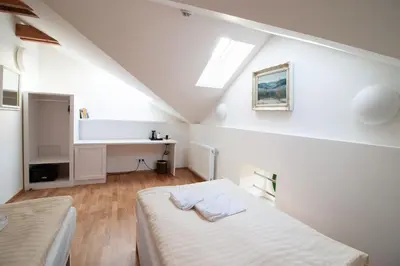 a white room with two beds and a desk at Pivovar Řevnice in Řevnice