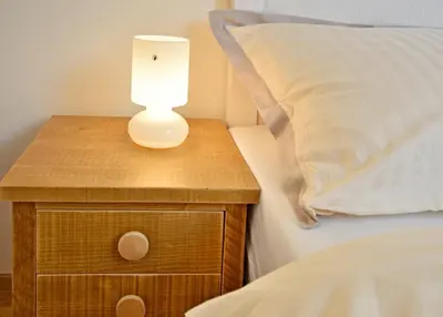 a lamp on a night stand next to a bed at Pivovar Řevnice in Řevnice