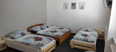 a room with two beds and a chair at Penzion Koupaliště in Litoměřice