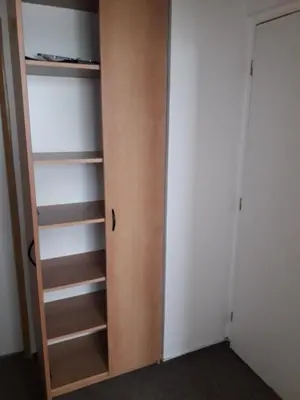 a closet with a wooden door and shelves at Penzion Koupaliště in Litoměřice