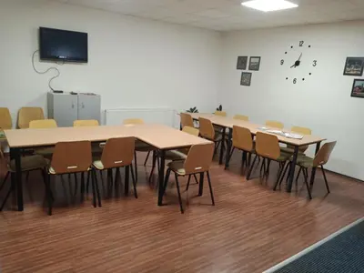 a classroom with tables and chairs and a flat screen tv at Penzion Koupaliště in Litoměřice