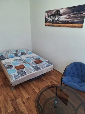 a bedroom with a bed and a chair and a glass table at Penzion Koupaliště in Litoměřice