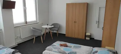 a bedroom with a bed and a table and chairs at Penzion Koupaliště in Litoměřice