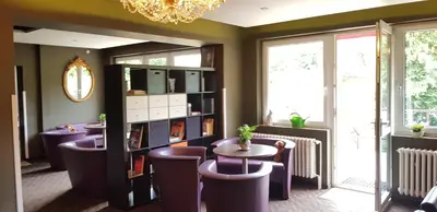 a restaurant with purple chairs and tables and a chandelier at M-Tourist in Prague
