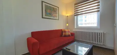 a living room with a red couch and a window at M-Tourist in Prague