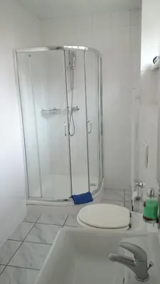 a white bathroom with a shower and a sink at M-Tourist in Prague