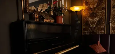 a piano in a room with a lamp and a mirror at M-Tourist in Prague
