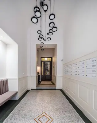 a hallway with a couch and a chandelier at Palace Dlazdena Central Apartment - New Town in Prague