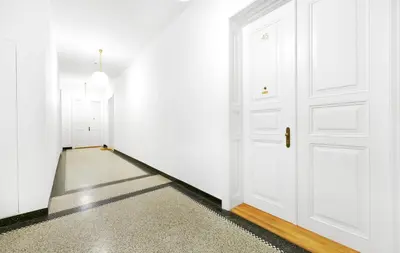 an empty hallway with white doors and a carpet at Palace Dlazdena Central Apartment - New Town in Prague