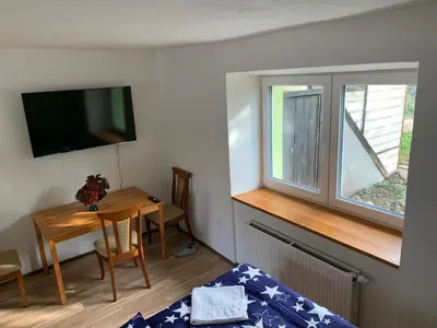 a room with a bed and a table and a window at Apartmány Kosmonosy, Hradištská 193 in Mladá Boleslav