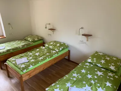 two beds in a room with green comforters at Apartmány Kosmonosy, Hradištská 193 in Mladá Boleslav