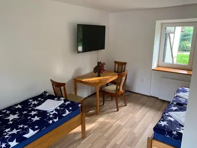 a room with a table and a bed and a bed and a table and chairs at Apartmány Kosmonosy, Hradištská 193 in Mladá Boleslav