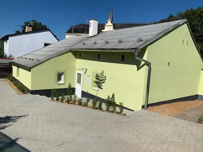 a yellow building with a black roof at Apartmány Kosmonosy, Hradištská 193 in Mladá Boleslav