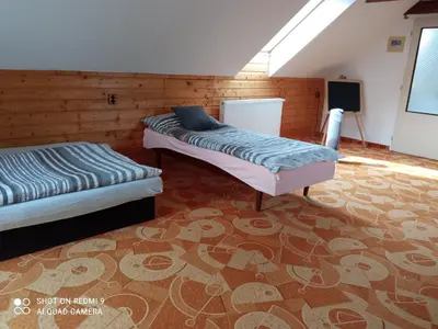 two beds sitting in a room with a rug at Celý rodinný dům na venkově in Kouřim