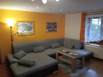 a living room with a couch and a table at Celý rodinný dům na venkově in Kouřim