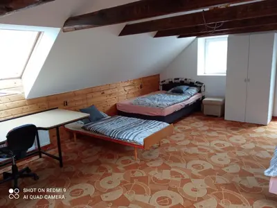 a room with two beds and a desk and a table at Celý rodinný dům na venkově in Kouřim