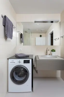 a white laundry room with a washing machine and a sink at Prague Days - Sunlit Studio near National Museum in Prague
