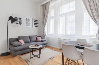 a living room with a couch and a table at Prague Days - Sunlit Studio near National Museum in Prague