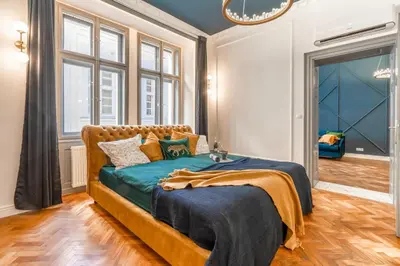 a bedroom with a large bed with blue sheets at Charles Bridge Suite by Riverside in Prague