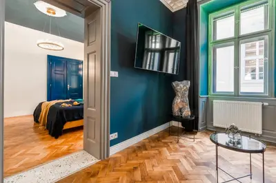 a room with blue walls and a bed and a table at Charles Bridge Suite by Riverside in Prague