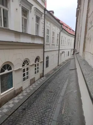 an empty street in a city with buildings at Charles Bridge Suite by Riverside in Prague