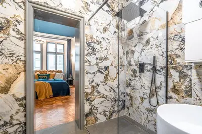 a bathroom with a shower and a bedroom at Charles Bridge Suite by Riverside in Prague
