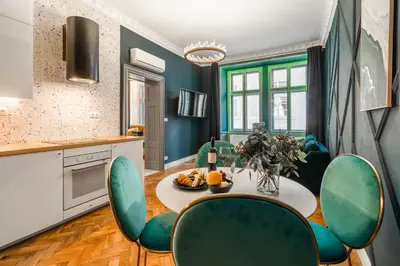 a kitchen with a table and green chairs at Charles Bridge Suite by Riverside in Prague