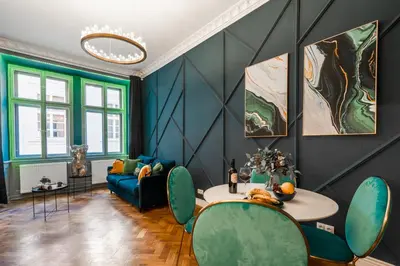 a living room with a blue couch and a table at Charles Bridge Suite by Riverside in Prague