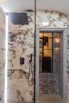 a bathroom with a walk in shower next to a door at Emperor Castle View Suite in Prague