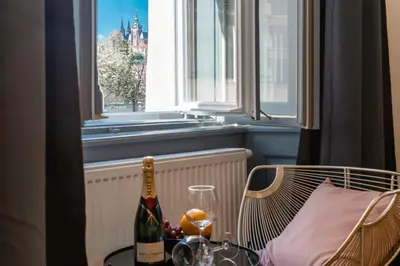 a bottle of wine sitting on a table next to a window at Emperor Castle View Suite in Prague