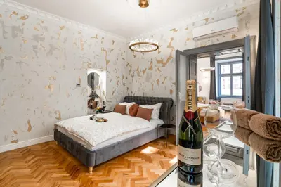 a bedroom with a bed and a bottle of wine at Emperor Castle View Suite in Prague
