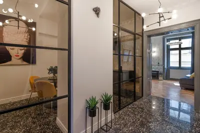 a hallway with glass doors and a table with plants at Emperor Castle View Suite in Prague