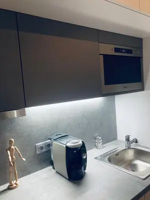 a kitchen with a toaster on the counter next to a sink at Apartement Blanc Harfa design in Prague